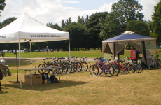Two gazebos in a park with bikes stood up beneath them